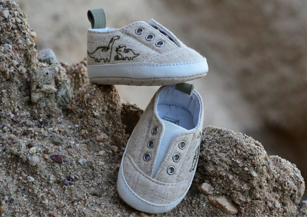 Two small toddler shoes placed on rocks outdoors, symbolising getting out of the house and everyday adventures