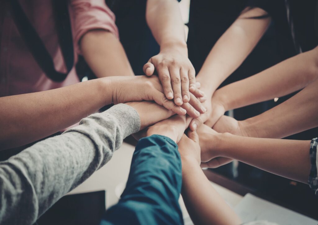 Hands stacked together representing community and shared purpose, a key part of ikigai.