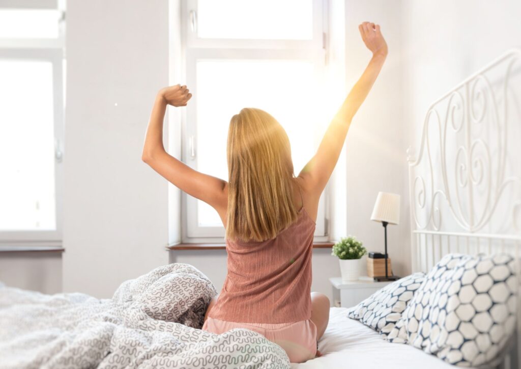 Woman stretching in morning light, symbolising waking up with purpose.